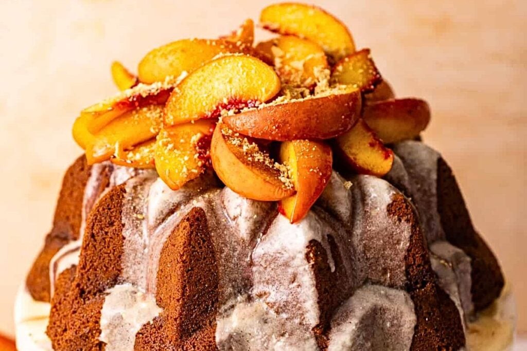 A pound cake piled high with peach cobbler.