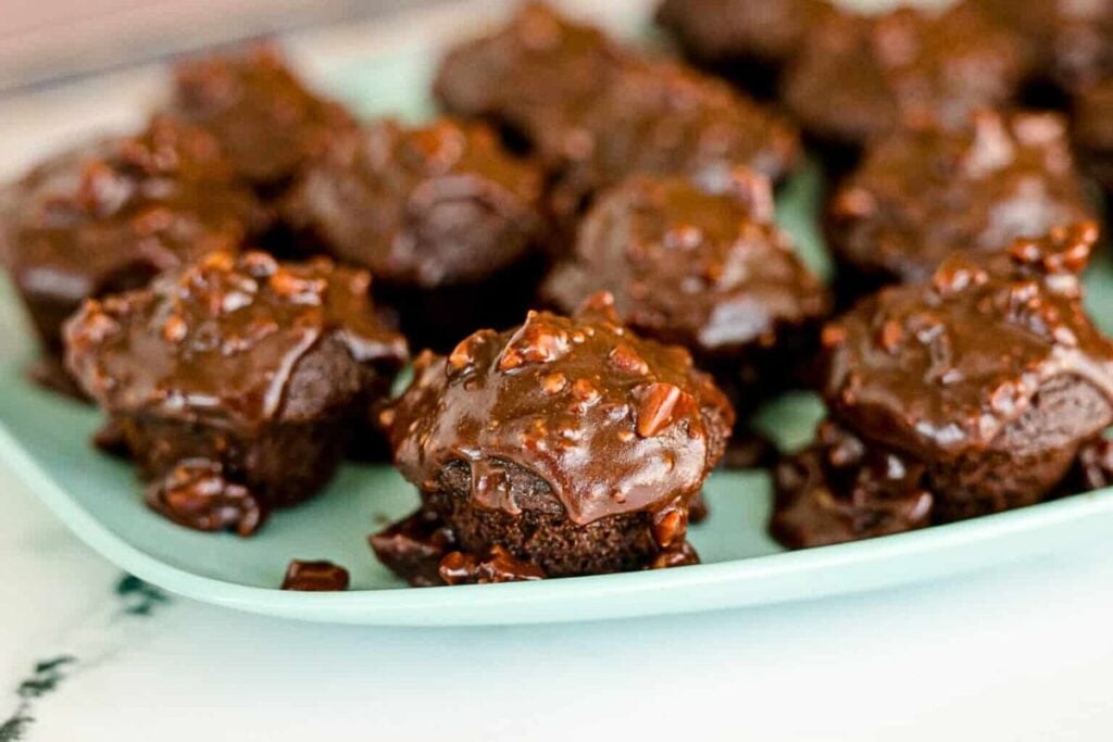 A plate of sheet cake bites, covered with Texas sheet cake icing.