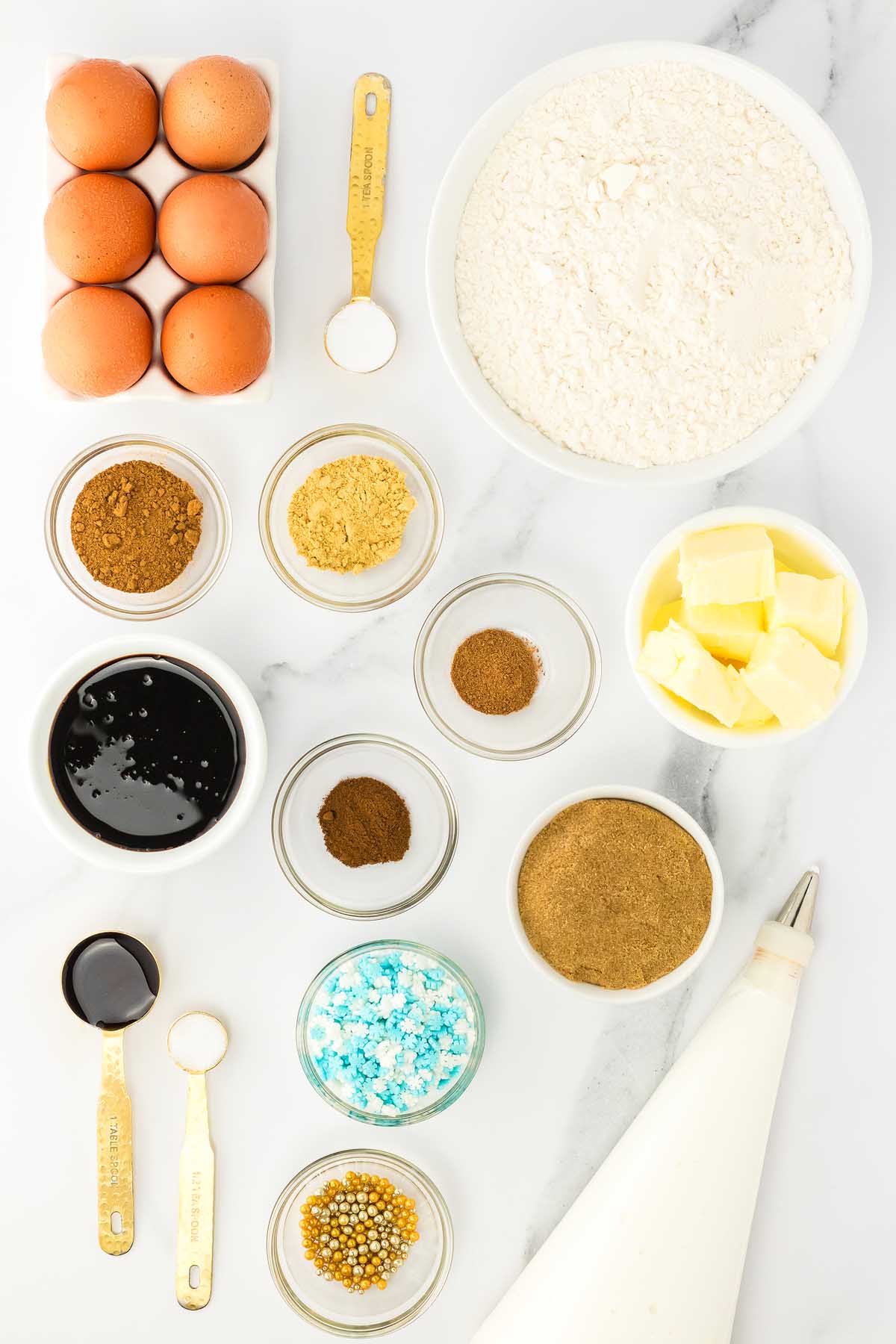 Baking ingredients including eggs, flour, spices, butter, molasses, sugars, sprinkles, and a piping bag—everything you need to make festive 3D Gingerbread Tree Cookies.