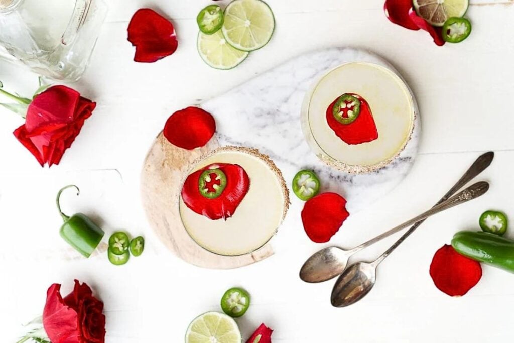 A jalapeno margarita  with jalapeno slices and rose petals.