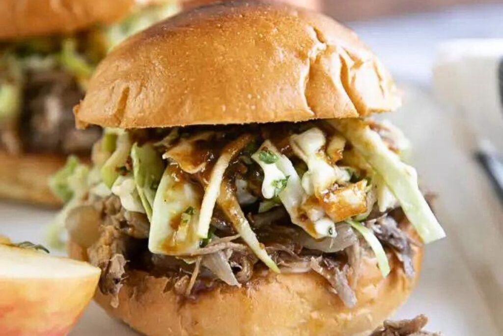 Slow cooker pulled pork with coleslaw on a bun.
