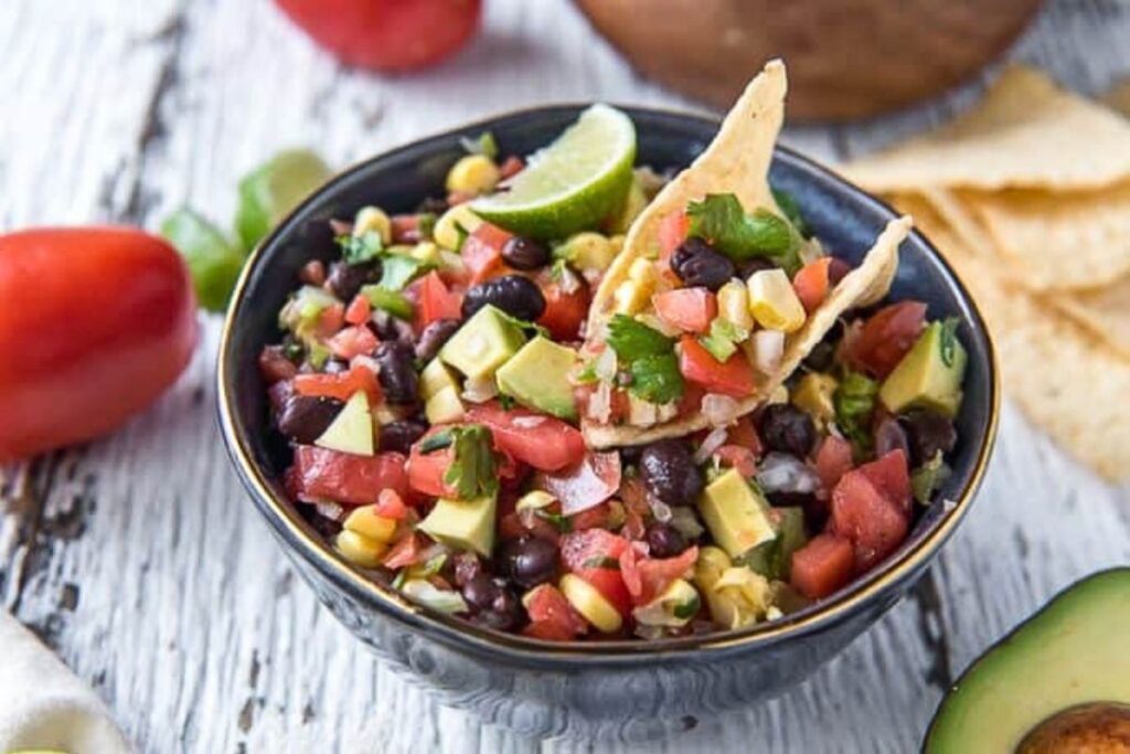 A colorful bowl of black bean, avocado and corn salsa.