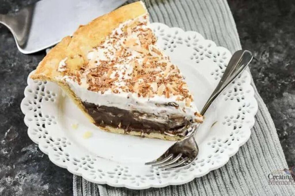A chocolate coconut cream pie slice on a plate. 