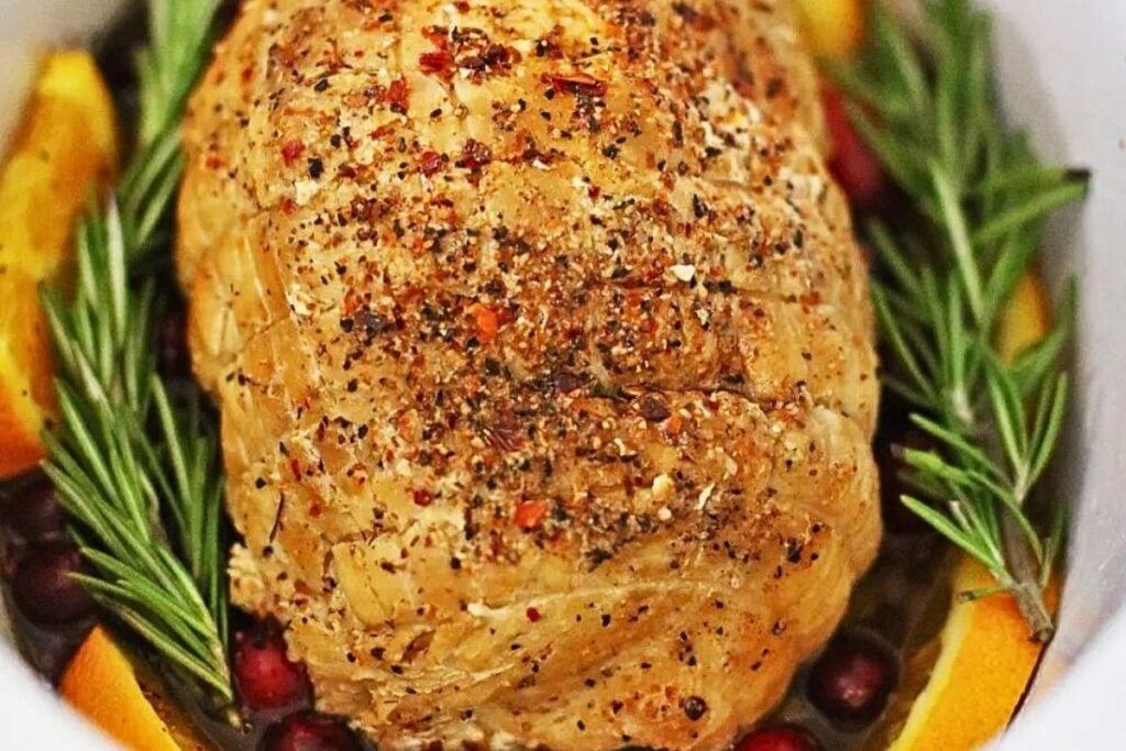 Turkey breast with cranberries and herbs in the crockpot.