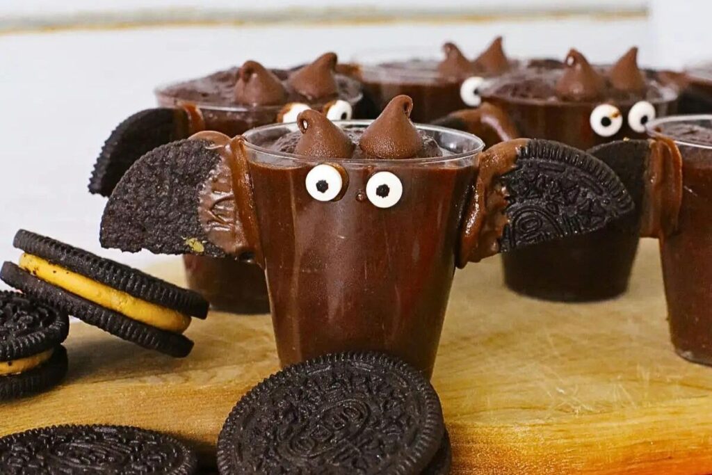 Pudding shots with oreo bat decorations.