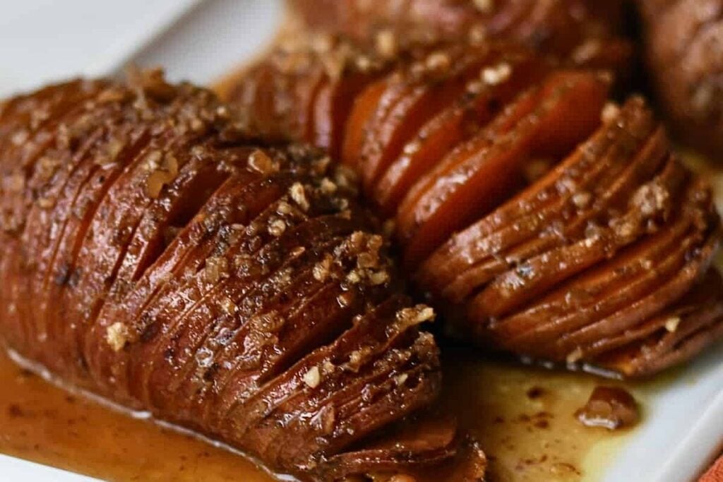 Sweet potatoes cooked hasselback style on a plate.