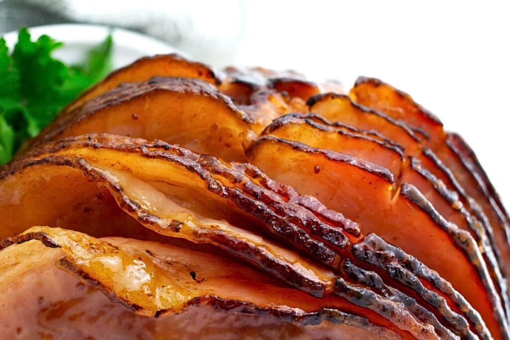 A pineapple glazed spiral sliced ham on a platter.