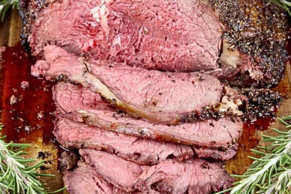 A perfectly roasted prime rib, sliced on a platter.