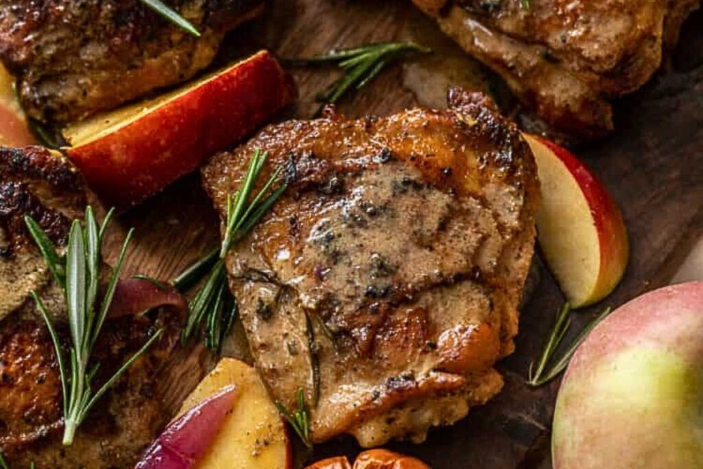 Chicken with glaze on a wooden cutting board.
