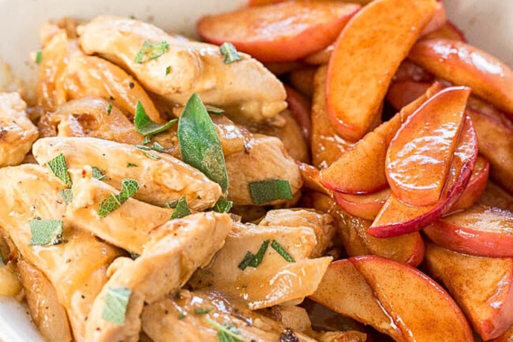 A plate of chicken with apples on the side.