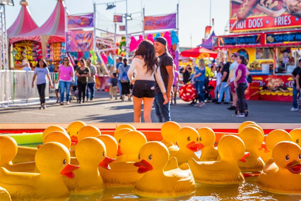 People stroll by the Ring A Duck game at the Arizona State Fair in Phoenix.