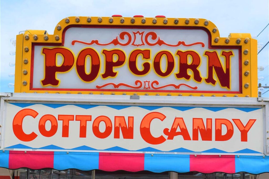Carnival food truck sign with bright neon colors.