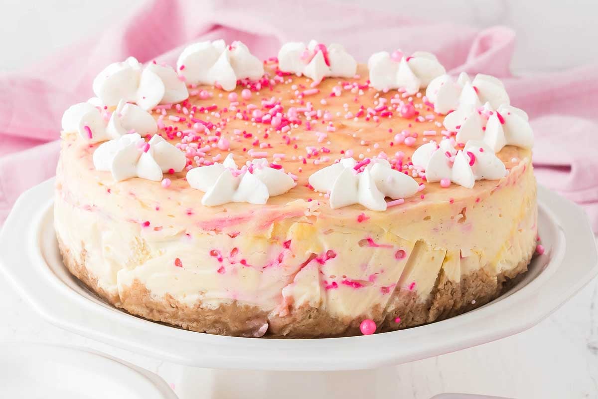 A cheesecake with pink sprinkles.