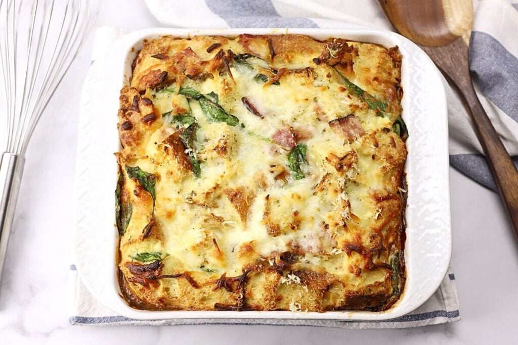 A casserole dish filled with ham and cheese breakfast strata.