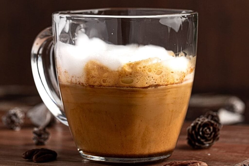A glass coffee cup with maple latte inside.