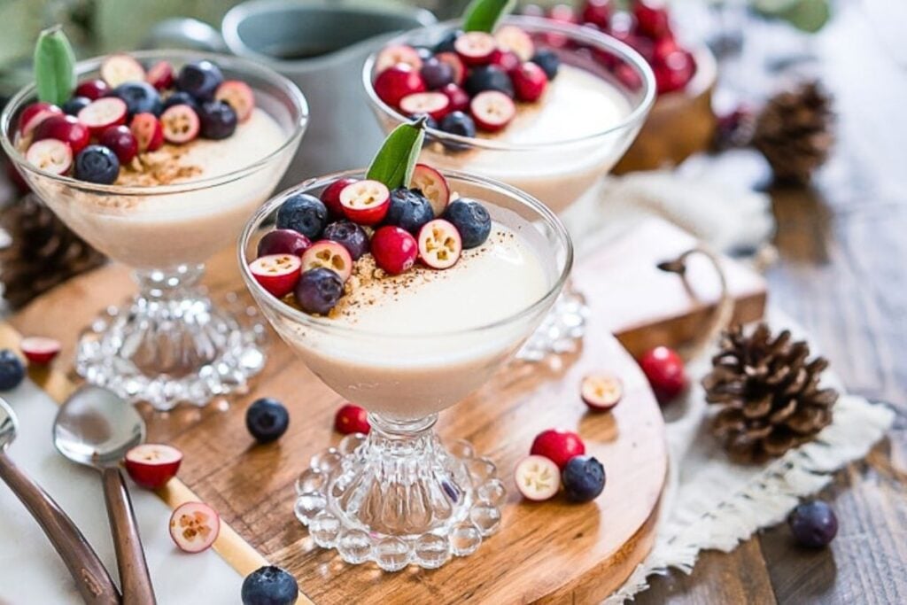 Dishes of maple panna cotta with blueberries and cranberries on top.