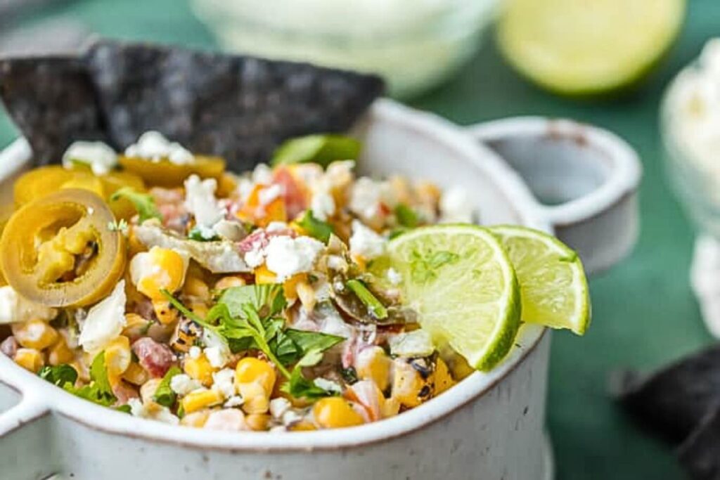 A dish of street corn salsa with a spoon.