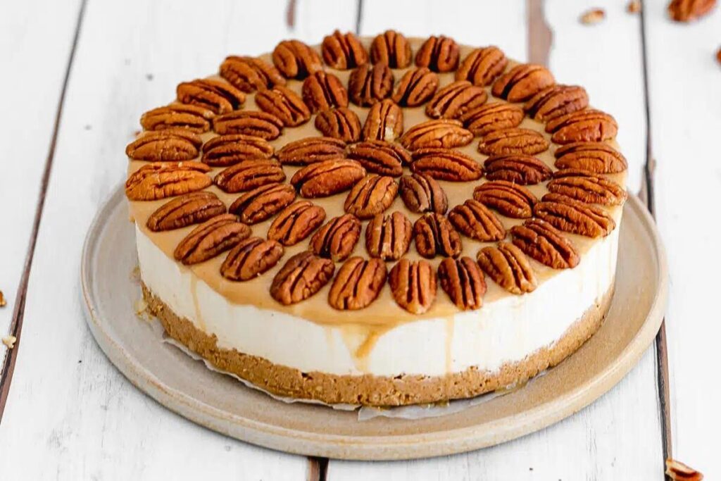 A cheesecake with pecans on top.