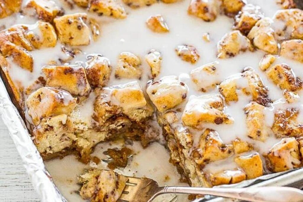 A pan of pumpkin cinnamon roll casserole with plenty of frosting.