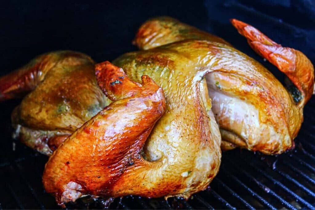 A spatchcock turkey smoking.