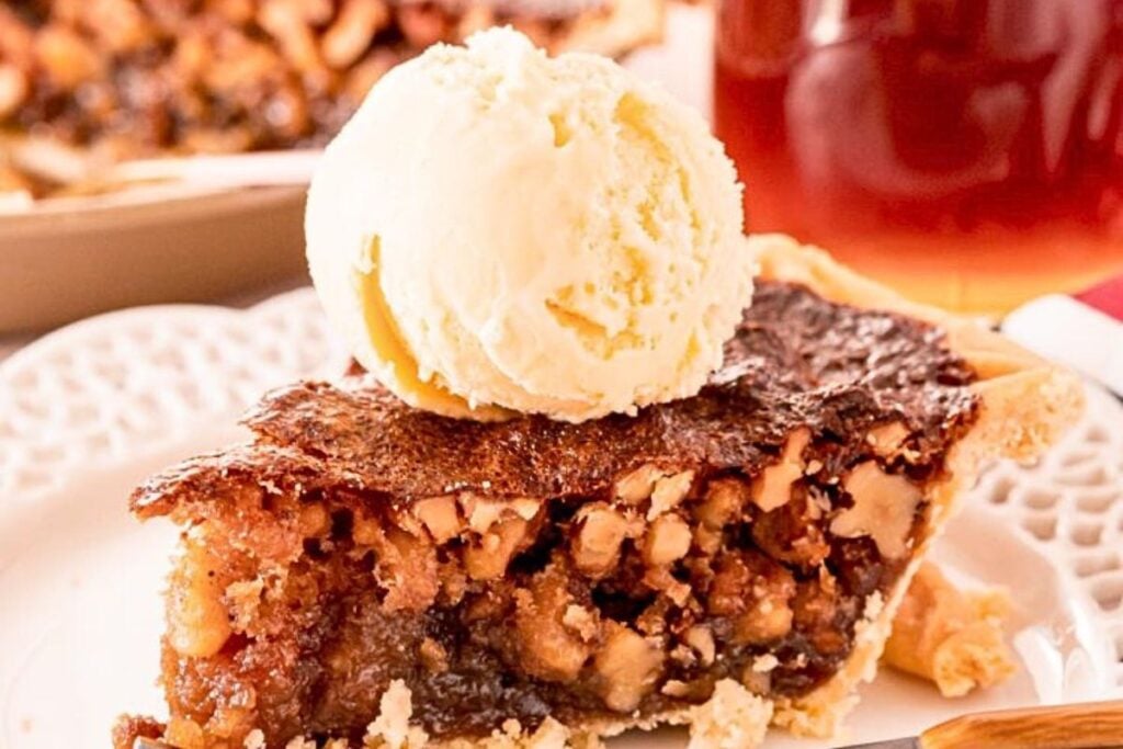A slice of maple walnut pie with a scoop of ice cream over the top.