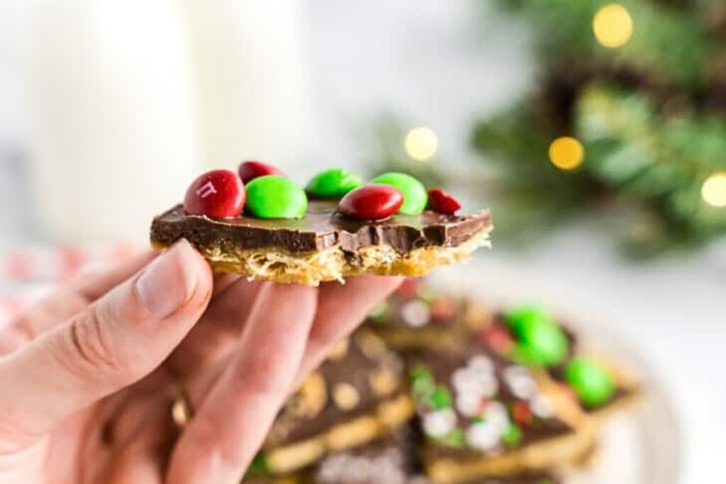 A hand holding a chunk of Christmas toffee crack.