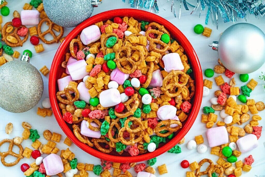 A bowl of Christmas mix with pretzels, candy and marshmallows.