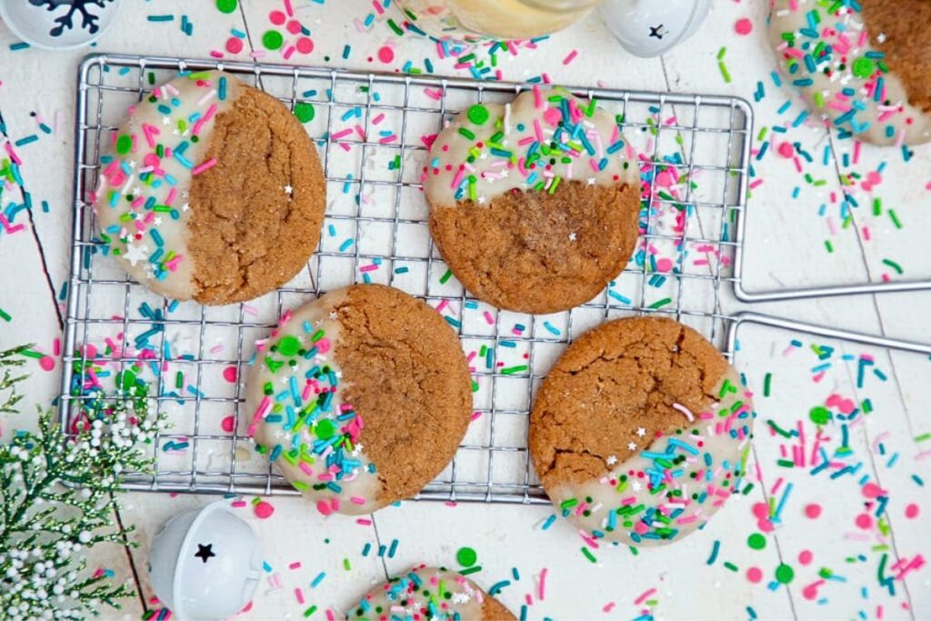 A cooling rack with gingerbread cookies, dipped in eggnog glaze and sprinkles.