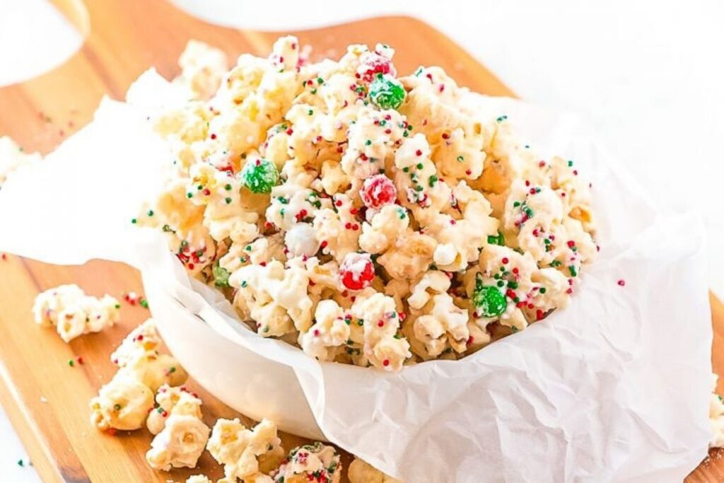 A bowl of popcorn with red and green M&M candies.