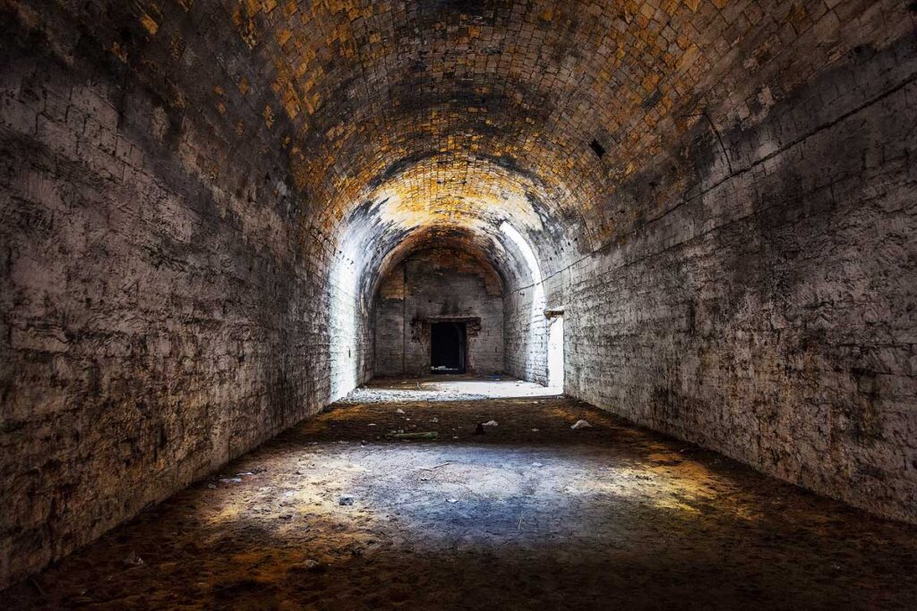 Old abandoned tunnel in the underground wine cellar. Entrance to the catacombs in Odessa, Ukraine. As a creative background for staged dark design.