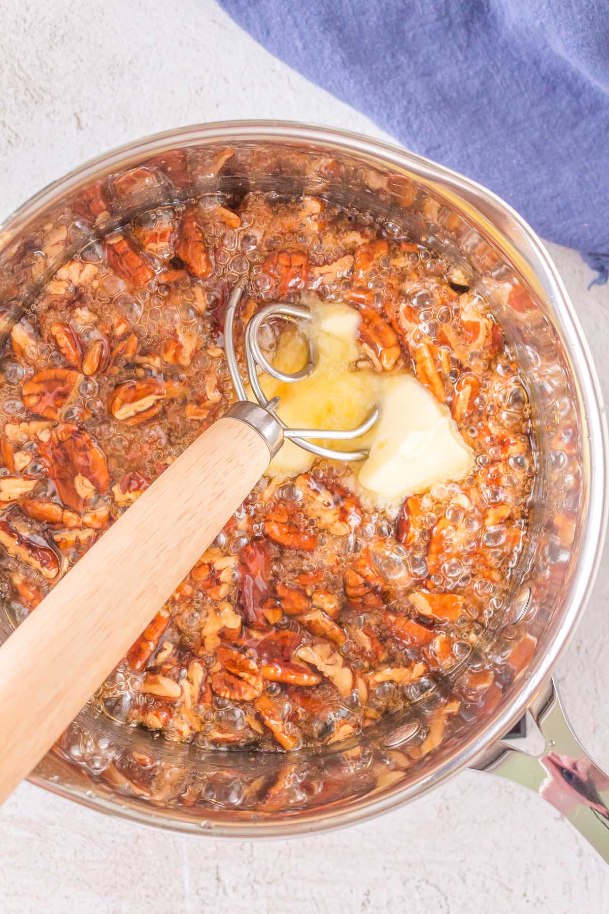 A pan with butter and pecans in it, creating a savory Nut Brittle.