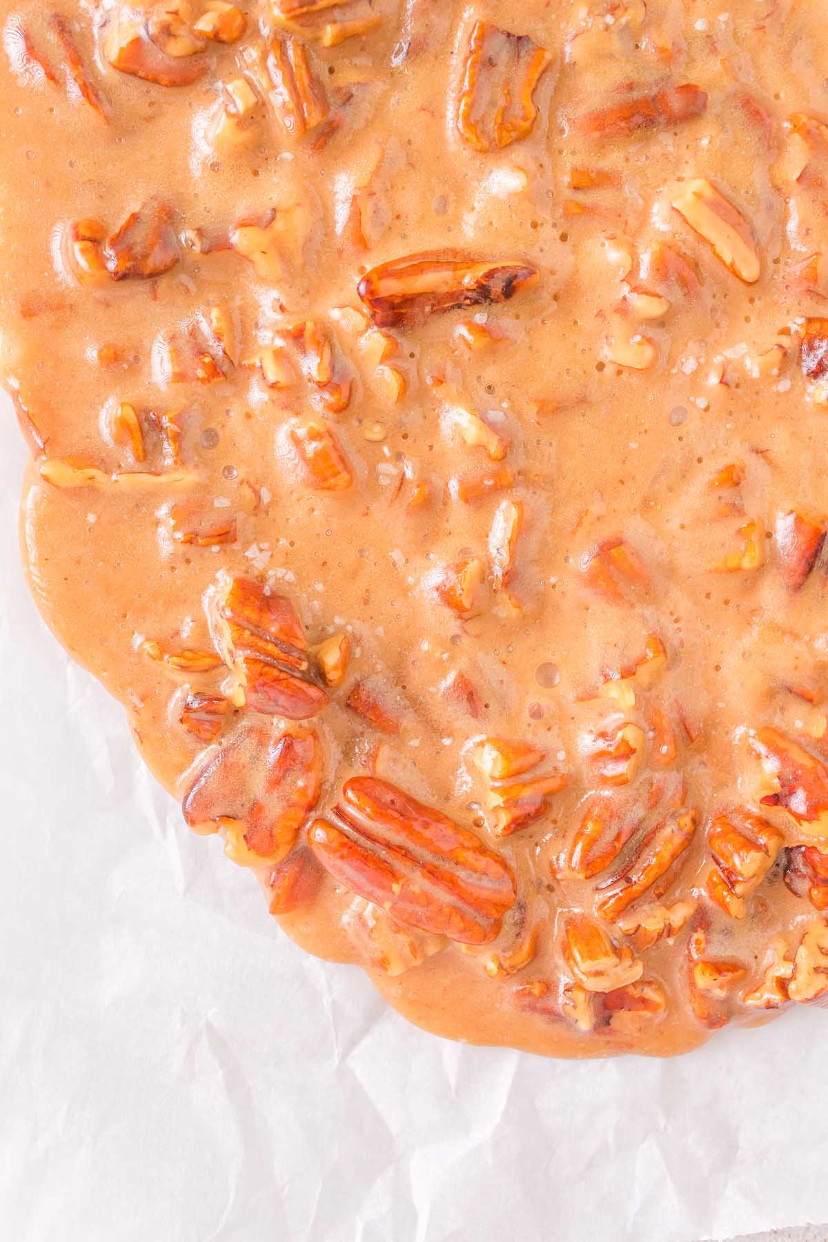 A plate of pecans covered in caramel sauce, perfect for nut brittle lovers.