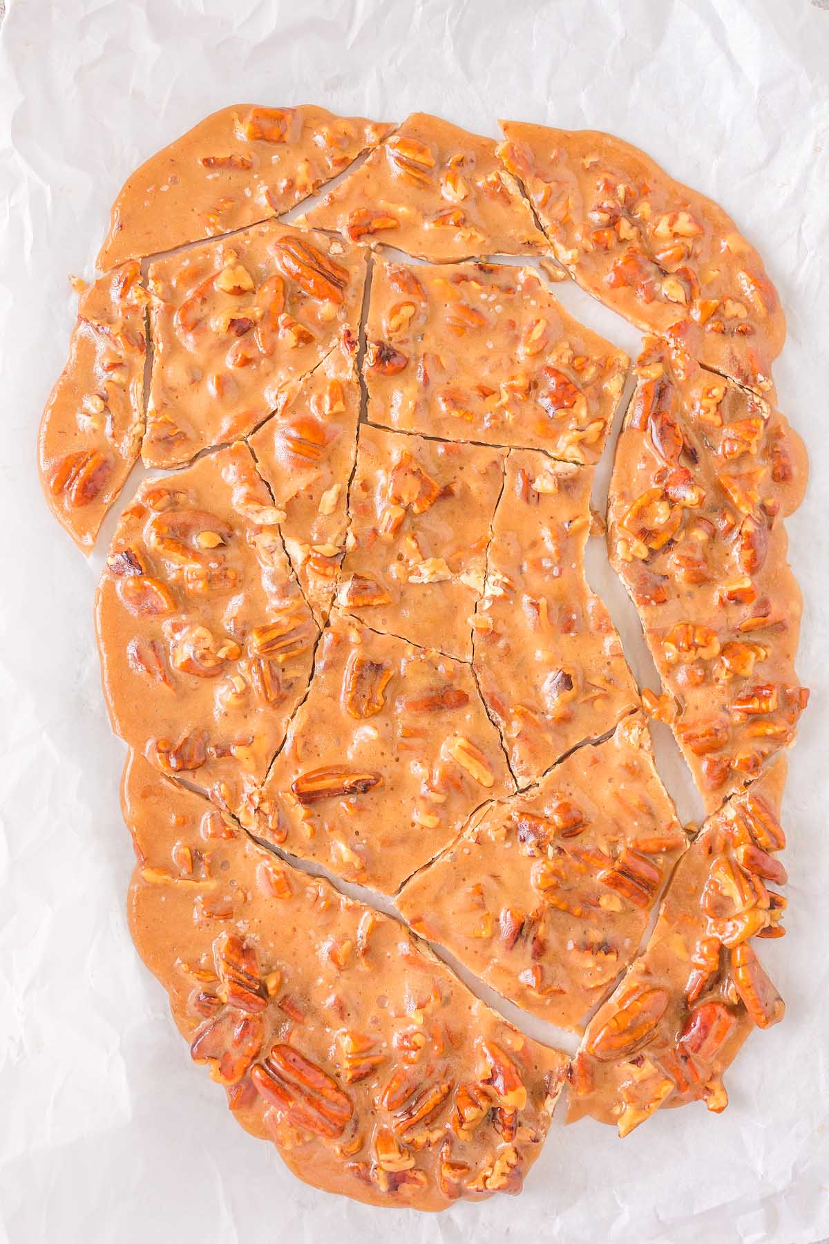 A piece of nut brittle on a piece of wax paper.