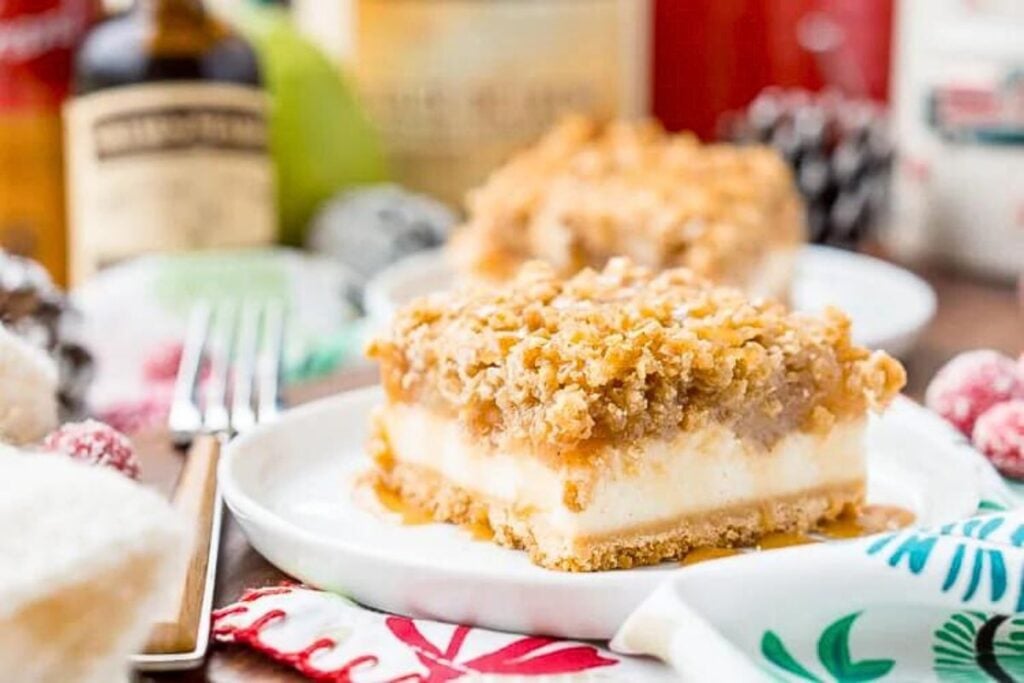 A cheesecake bar on a plate, with crumb topping.