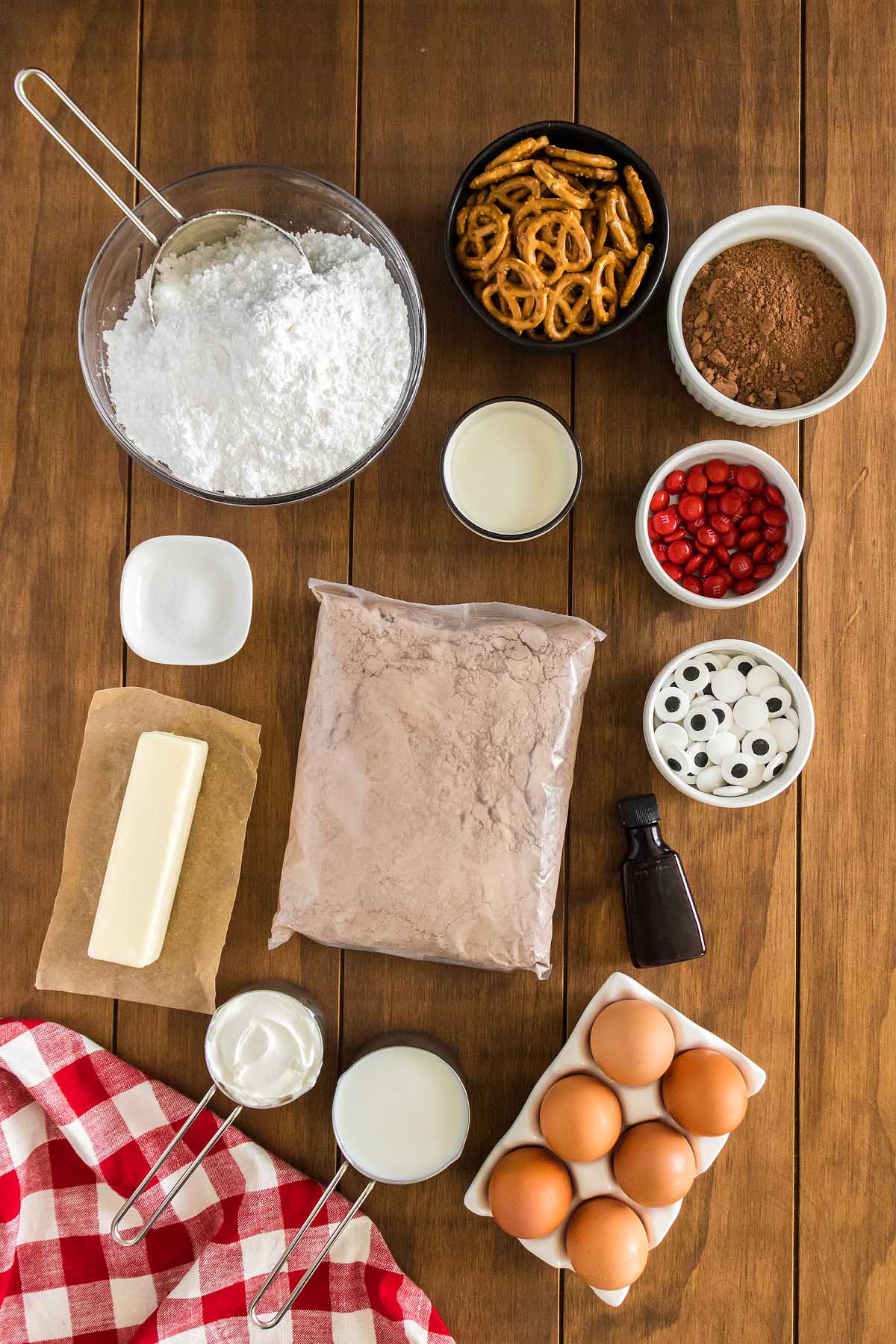 A festive Christmas cupcake, decorated like a reindeer, sits on a rustic wooden table.