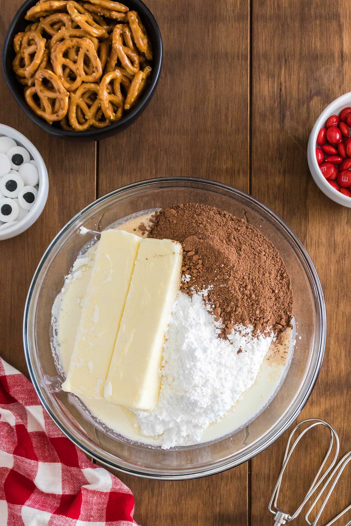 A bowl of ingredients for reindeer cupcakes on a wooden table.