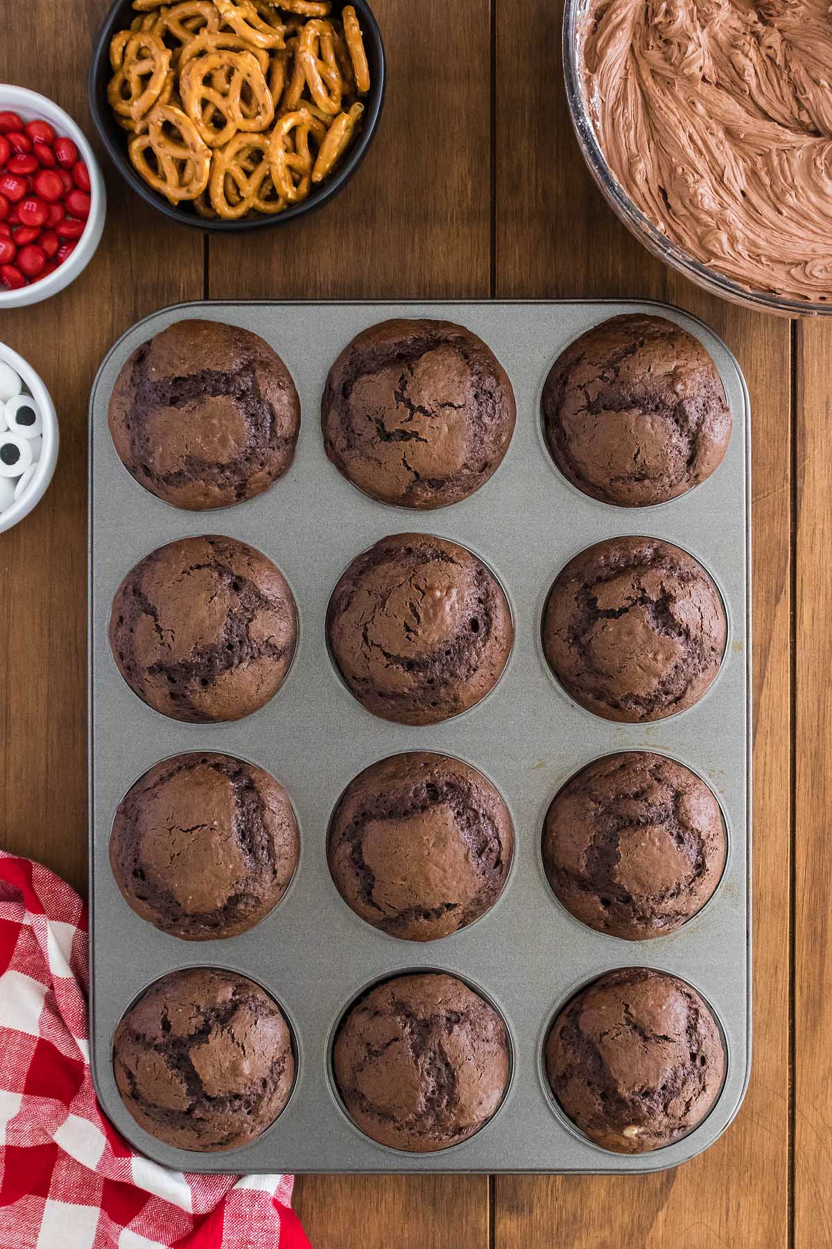 Chocolate cupcakes in a muffin tin with pretzel sticks, decorated like a reindeer.
