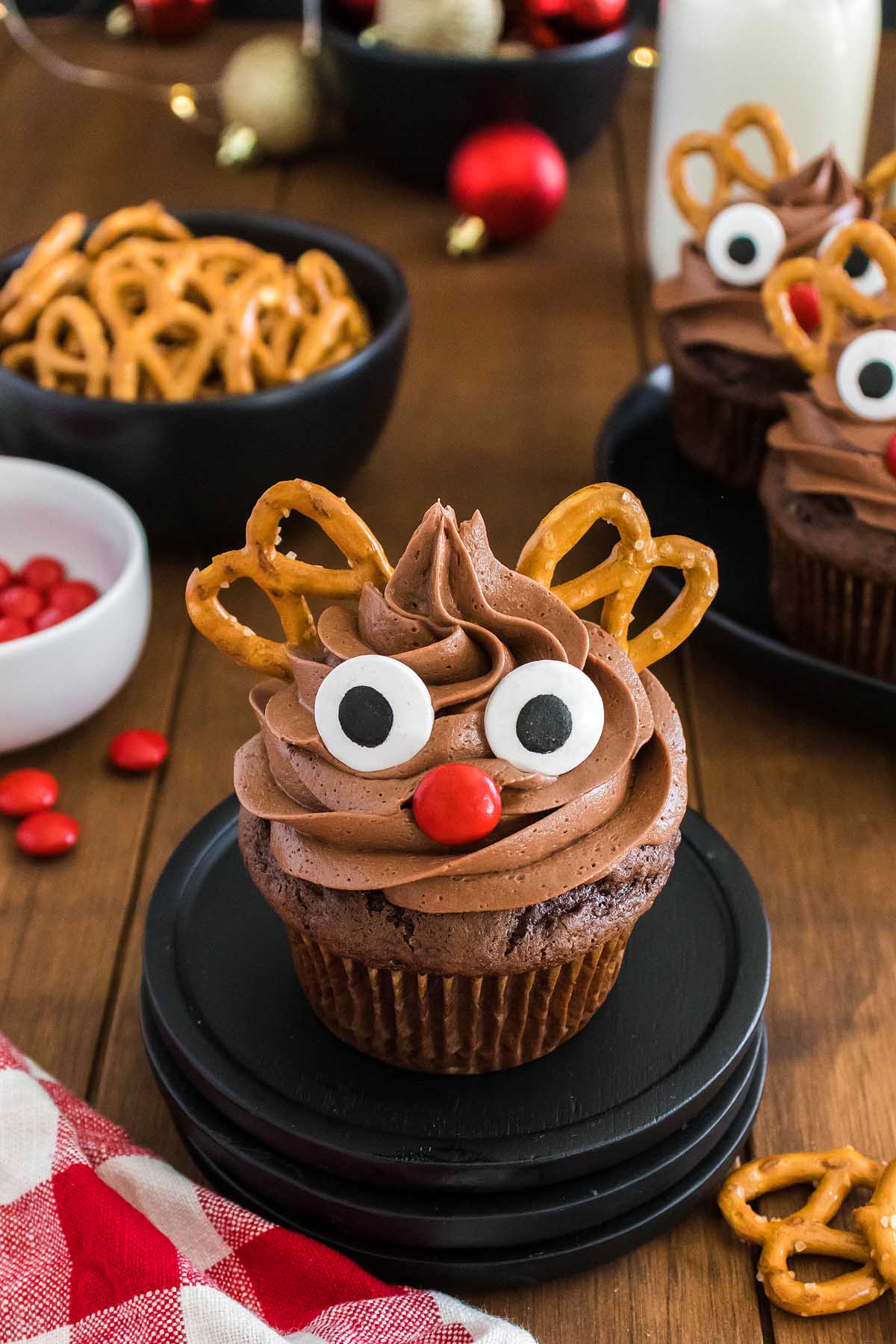 Chocolate reindeer cupcakes decorated with pretzels and pretzel sticks.