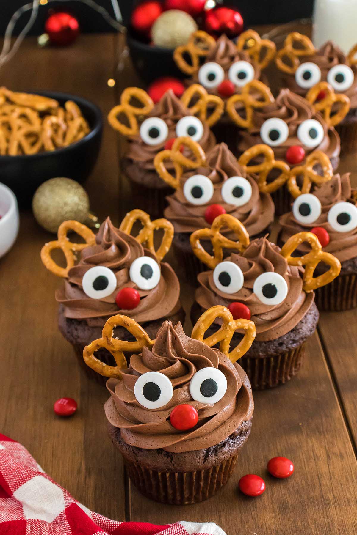 Christmas reindeer cupcakes with pretzels on a wooden table.