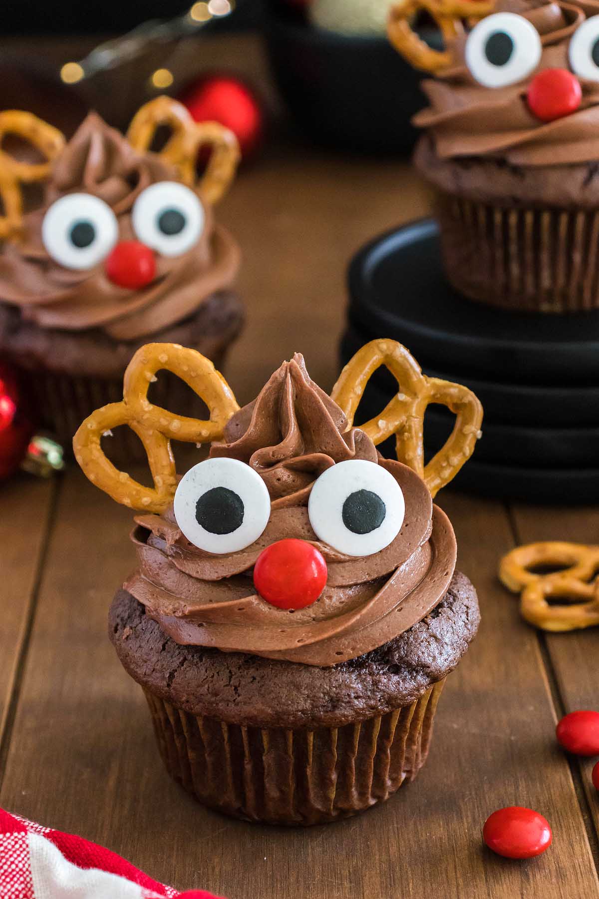 Reindeer cupcakes with pretzels on top.