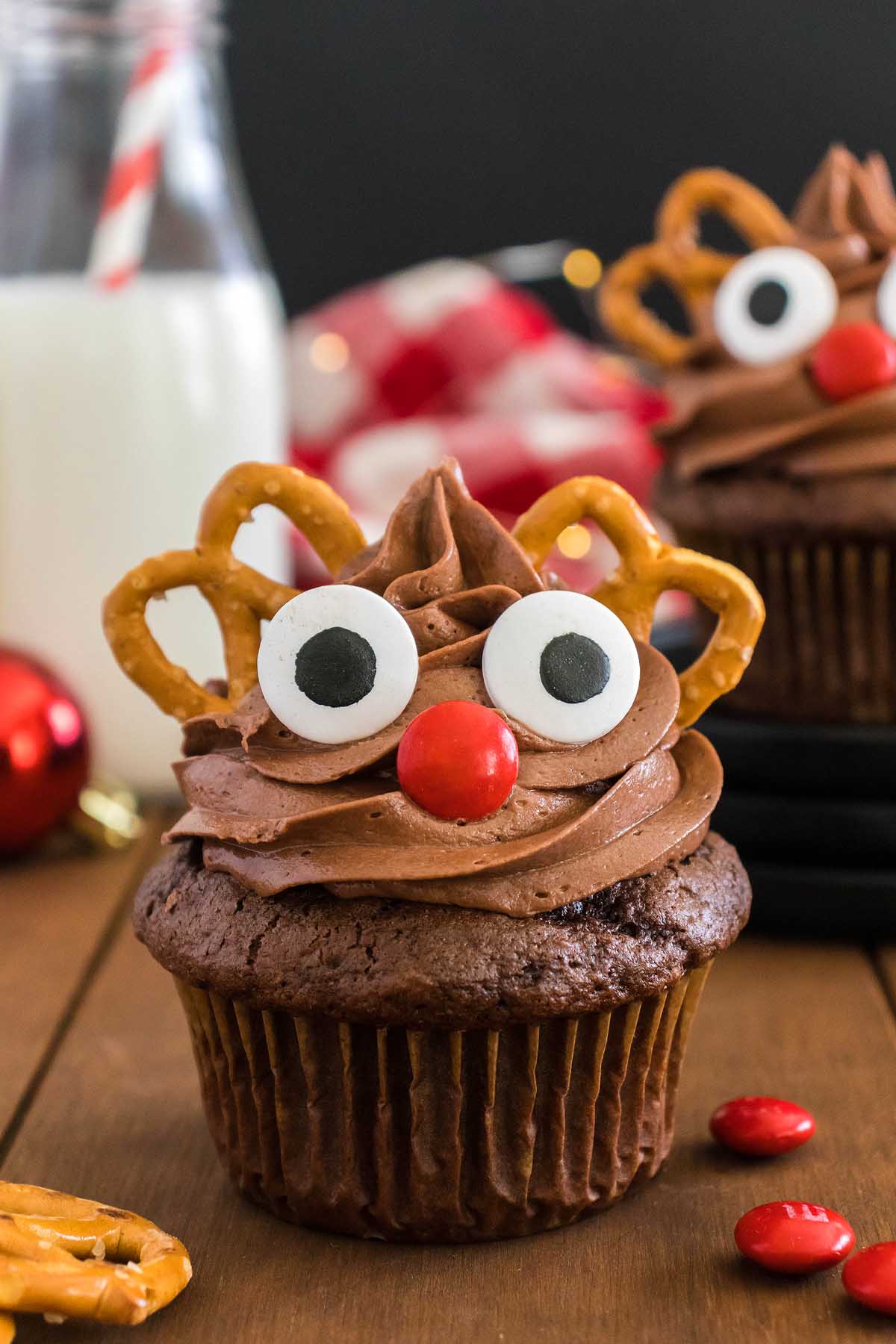 Reindeer cupcakes with chocolate decorations on a wooden table.