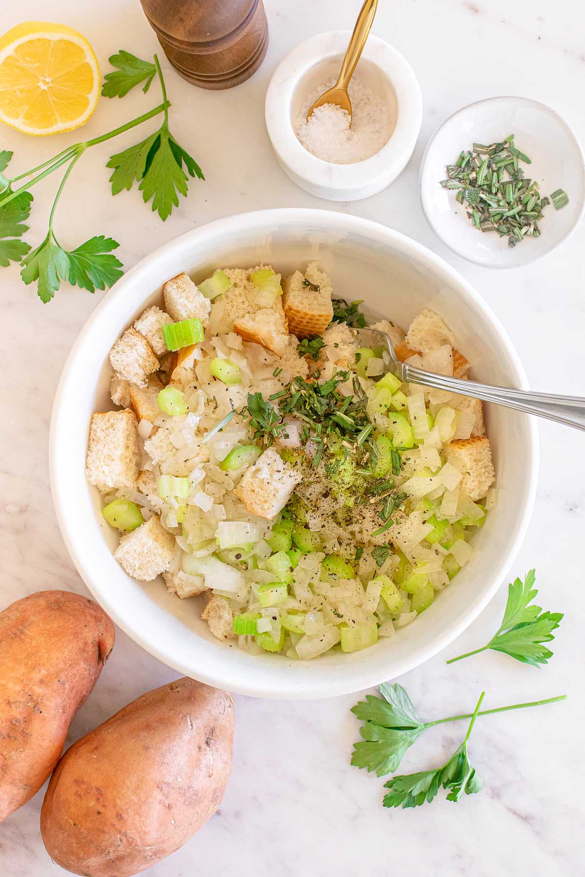 A bowl of mashed sweet potatoes with parsley and herbs, perfect for Thanksgiving.