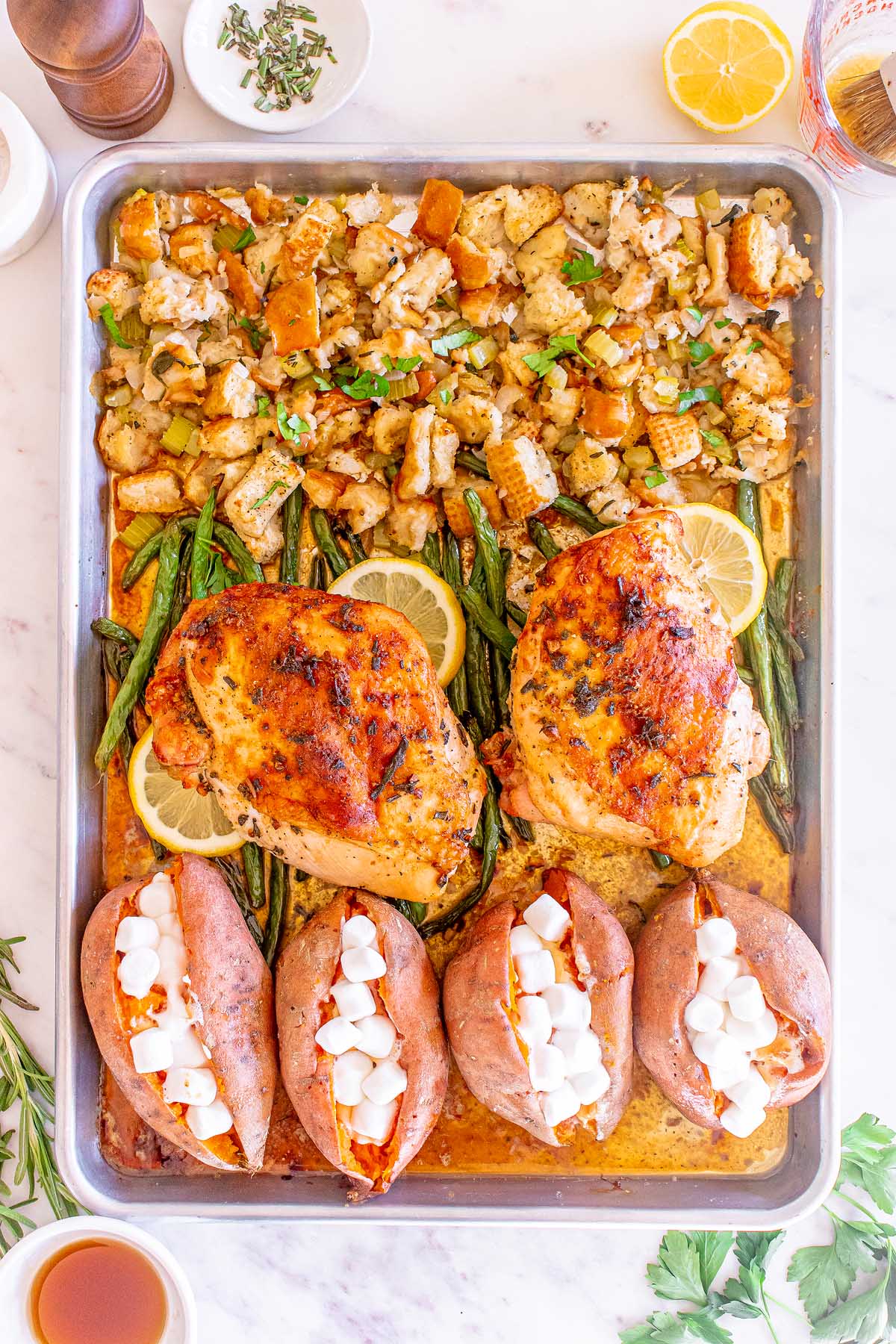 Roasted turkey, potatoes, and green beans on a baking sheet.