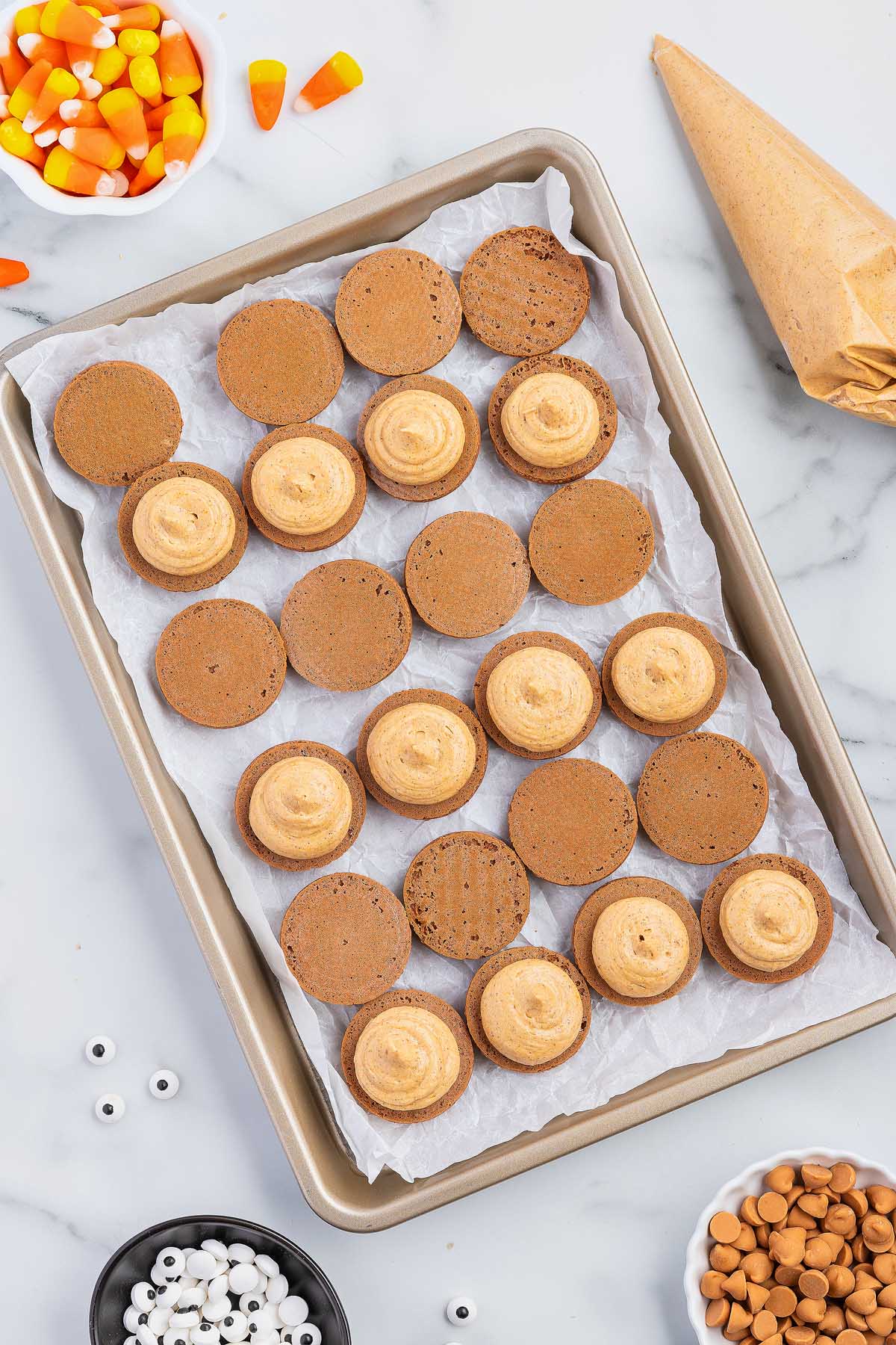 A baking sheet filled with cookies with cream filling.