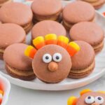 Thanksgiving macarons with candy corn on a plate, perfect as a festive treat for the holiday season.