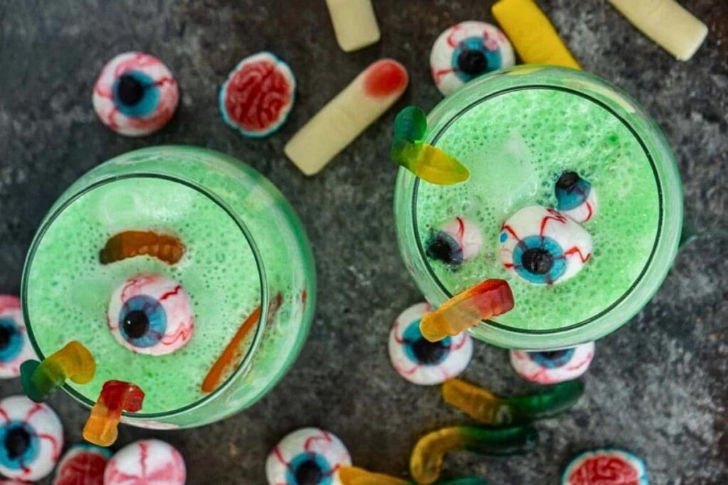 A green punch with gummy candies scattered around.