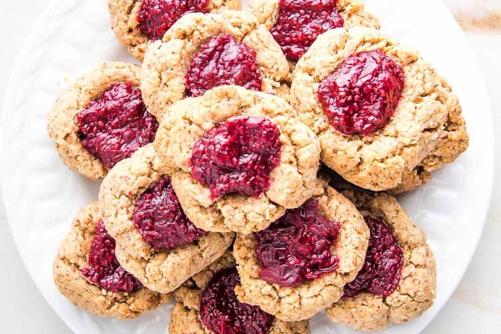 A round-up of gluten-free oatmeal cookies topped with raspberry jam.