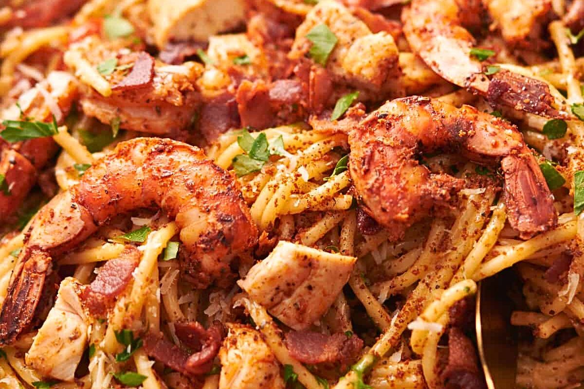 A pot of pasta with chicken, shrimp and spices.