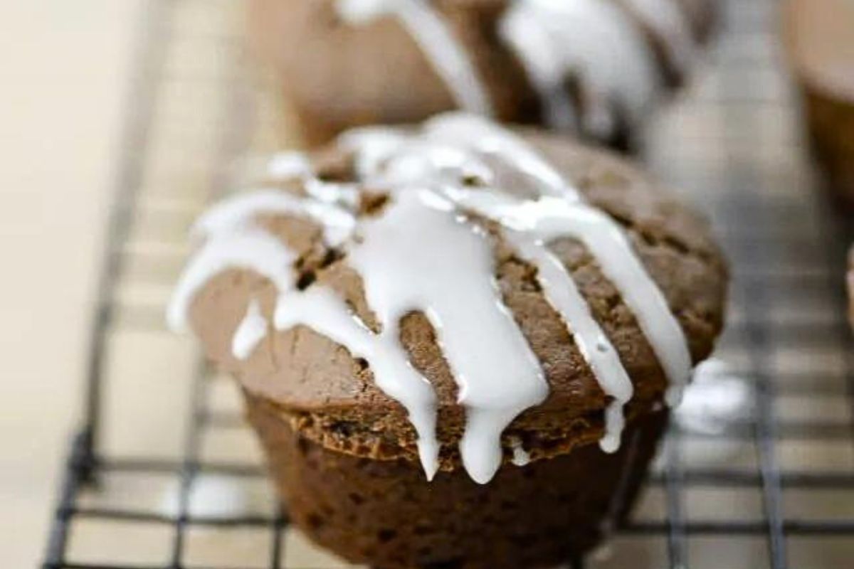 Lemon glazed gingerbread muffins on a cooling rack.