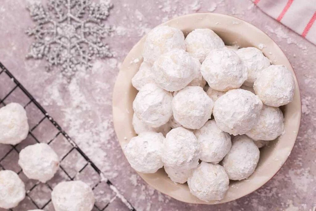 Round up of gluten-free powdered sugar cookies in a bowl.